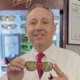 Eye Dr. holds a pair of bronze prescription sunglasses