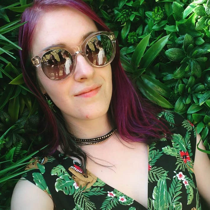 Woman in front of plants wearing jasmine Sunglasses