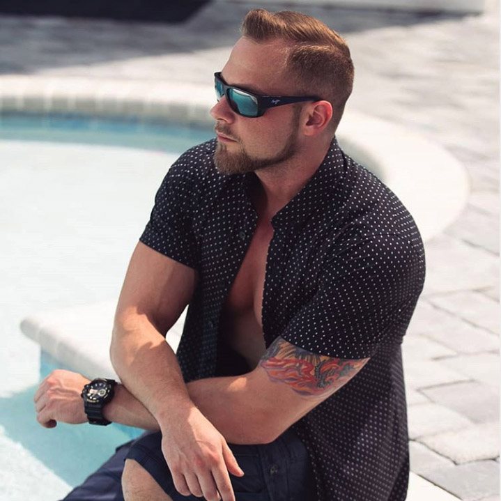 Man posing by pool wearing wrap sunglasses