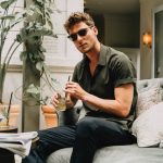 Man Sitting on Couch Wearing Translucent Dragonfly Sunglasses
