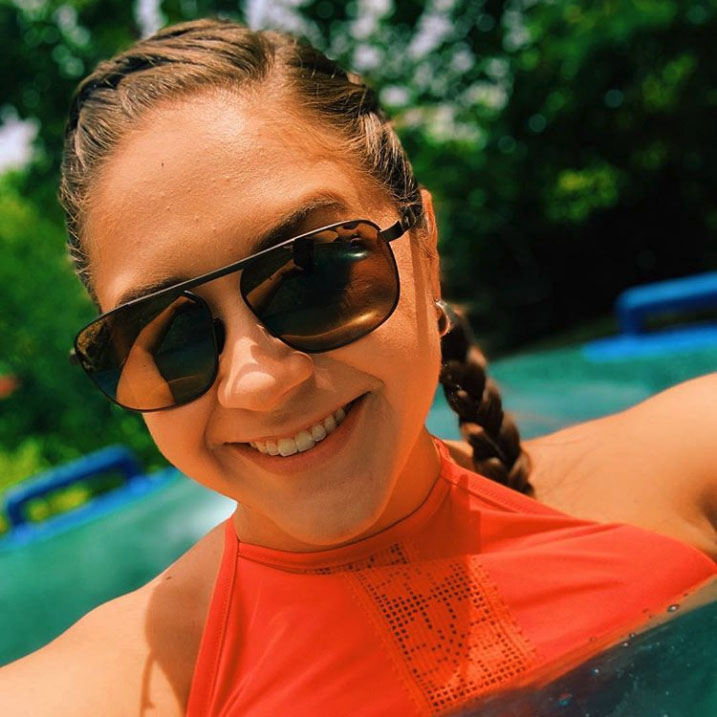 Woman in pool wearing Waihe'e Ridge sunglasses