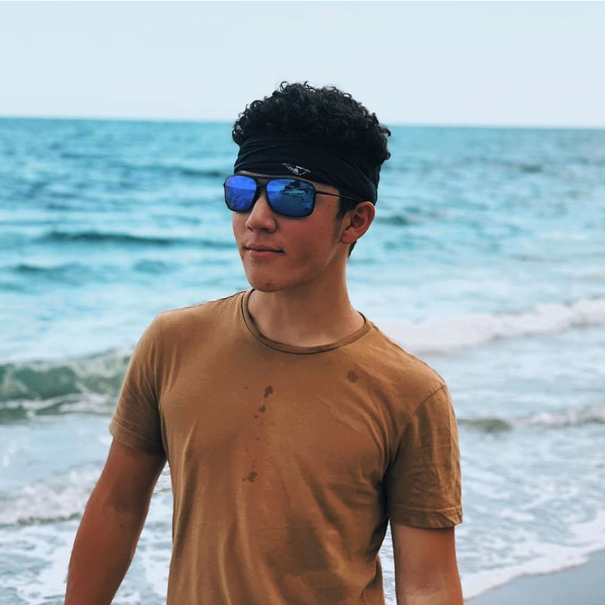 Man at Beach wearing Rust Colored t-shirt and Blue Hawaii Kuapo Gap Sunglasses