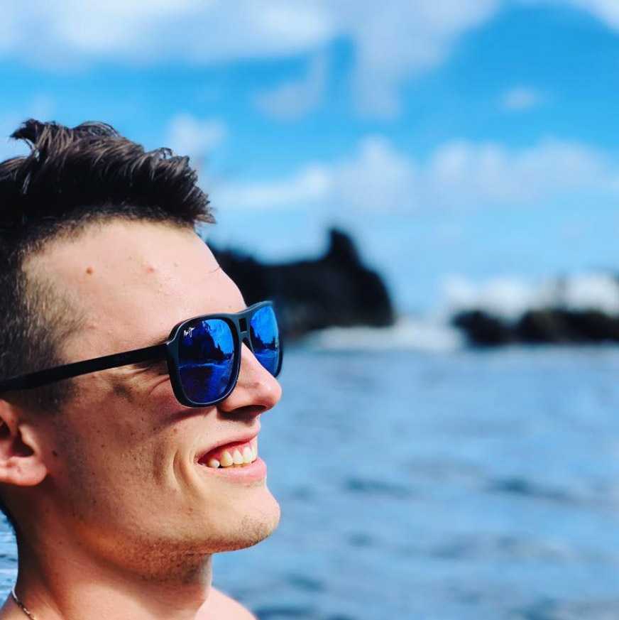 Man at beach wearing matte black Little Maks with Blue Hawaii lens