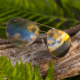Walaka sunglasses with Satin Sephia frame and HCL® Bronze lenses, resting on a log