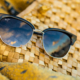 Black cat eye sunglasses, resting on a woven basket.