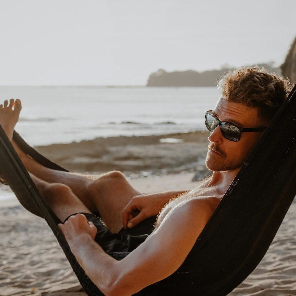 A man lounging next to the beach