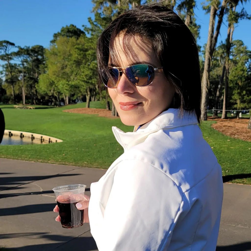 A woman holding a cup on a golf course