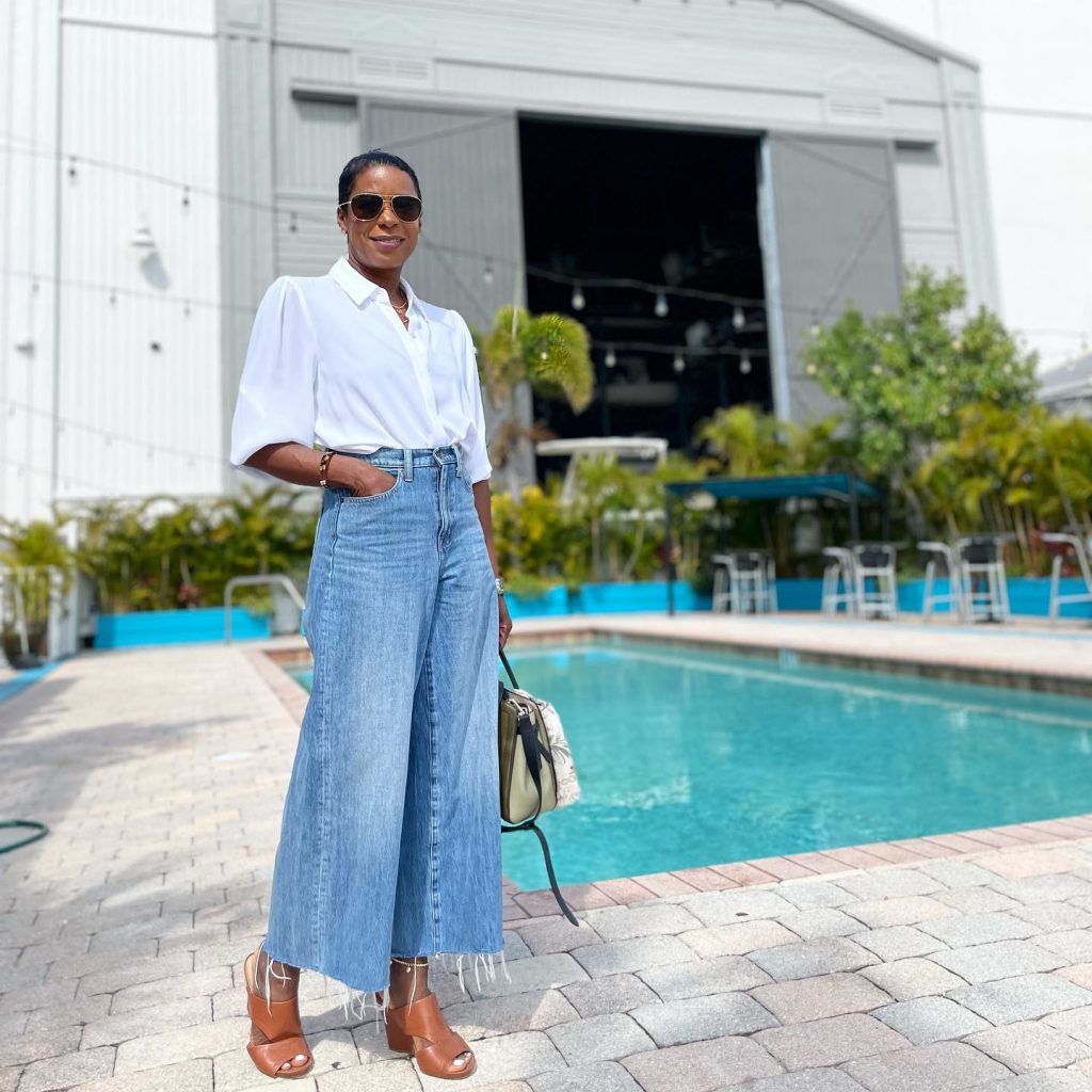 A woman posing next to a swimming pool