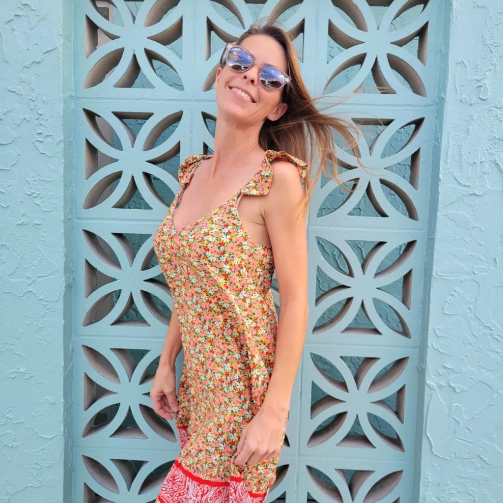 A woman next to a decorative frame