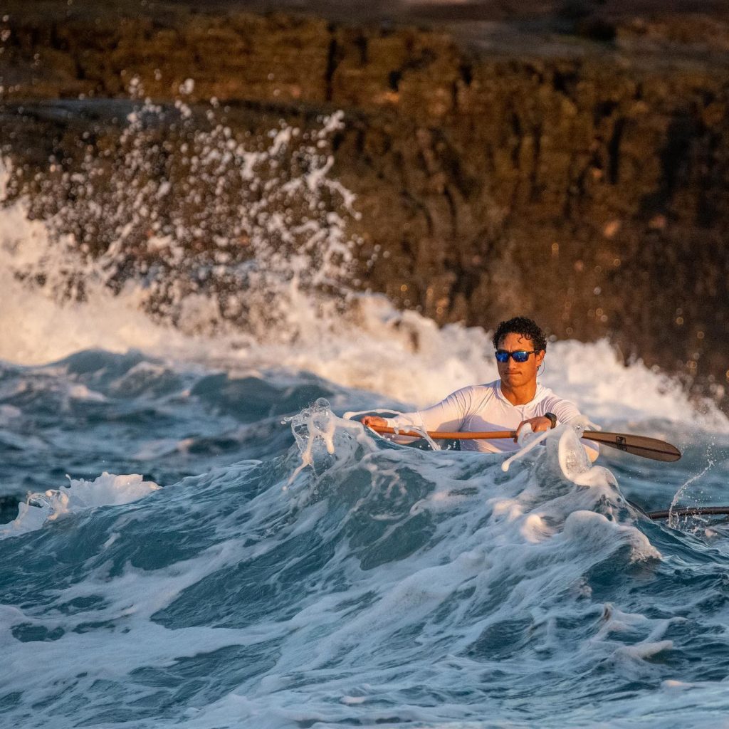 A man kayaking at sea