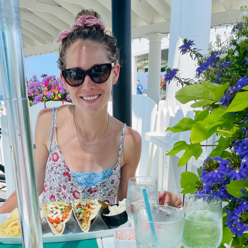 Woman in black sunglasses poses for a picture at a resturaunt