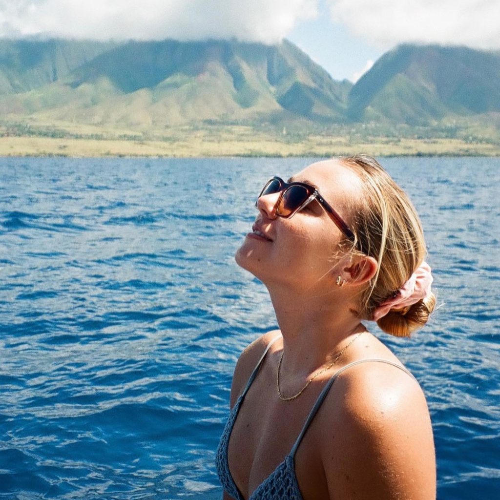 A woman in the water with mountains in the background