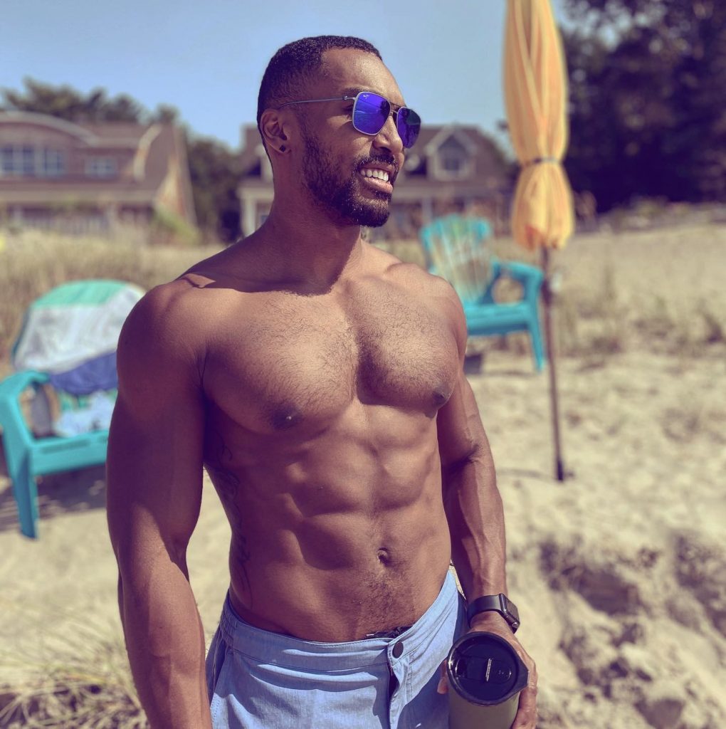A man in blue shades standing on the beach